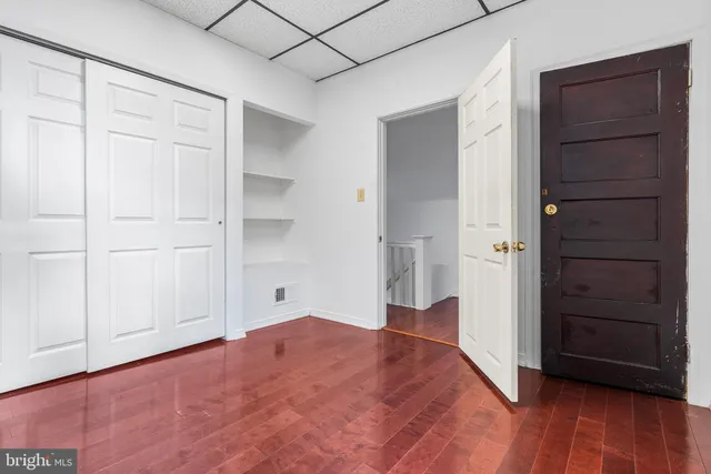 a view of empty room with cabinet and wooden floor