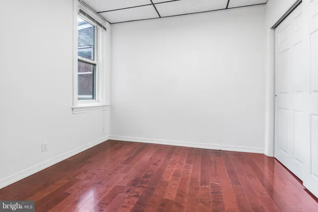 a view of a small space with wooden floor and a window