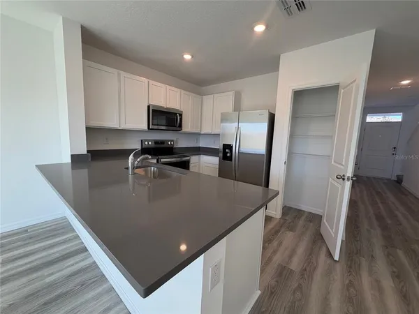 a kitchen with stainless steel appliances granite countertop a sink a stove and a refrigerator