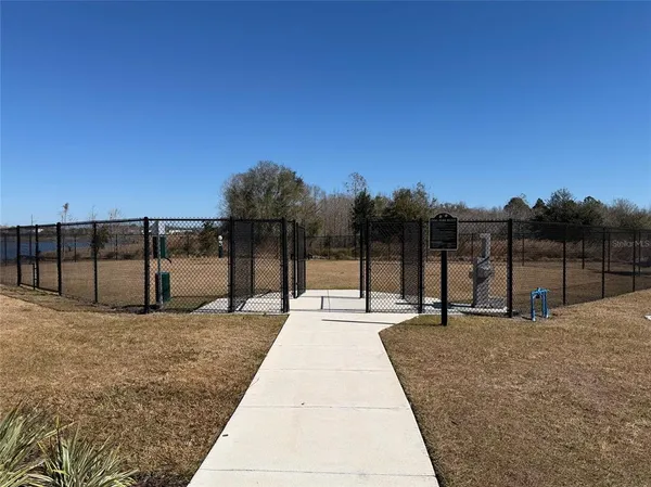 a swimming pool with outdoor seating and house in the background