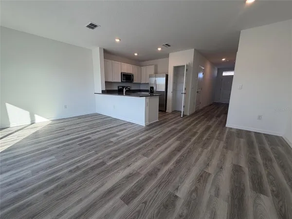 a view of kitchen with granite countertop cabinets and refrigerator
