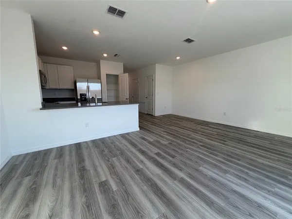 a view of a kitchen with kitchen island wooden floor center island and stainless steel appliances