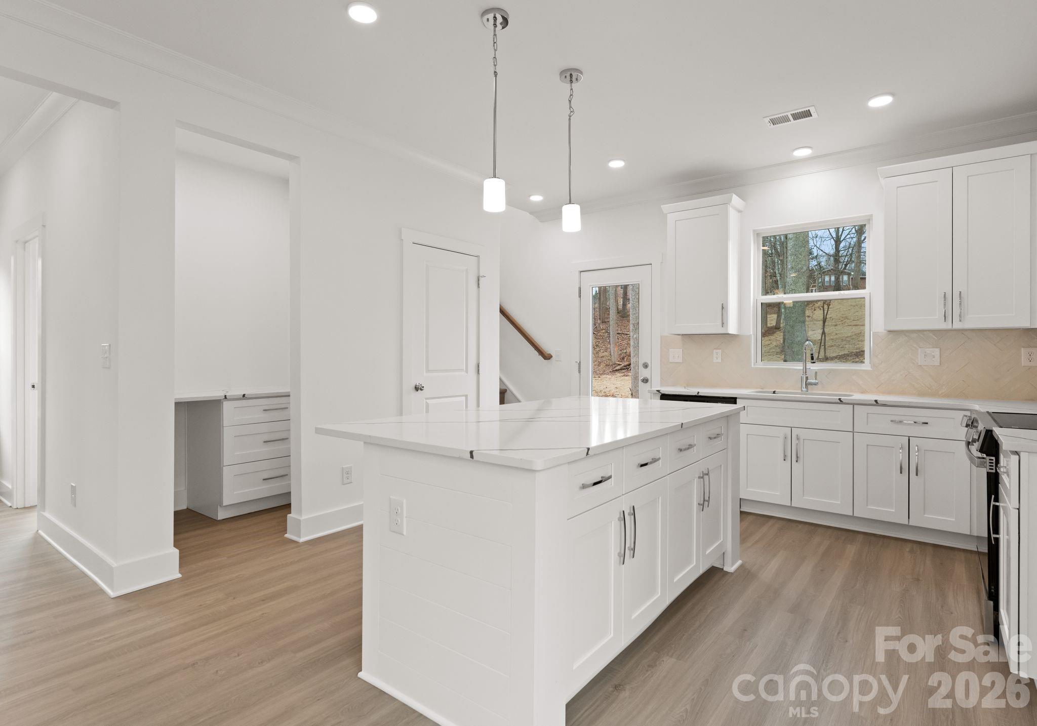 1906 Rucker Road Shelby, NC 28152 - Photo 4 of 21 a large white kitchen with a lot of cabinets and wooden floor
