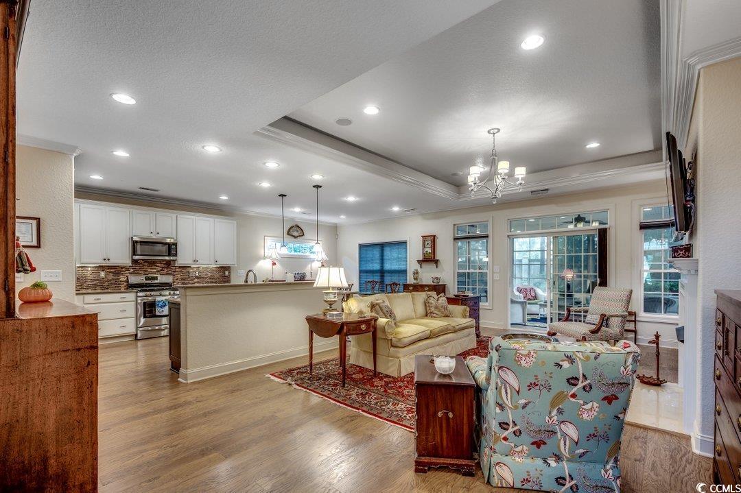 908 Corrado Street Myrtle Beach, SC 29572 - Photo 15 of 33 Living room featuring crown molding, a raised ceiling, a chandelier, light wood-type flooring, and recessed lighting