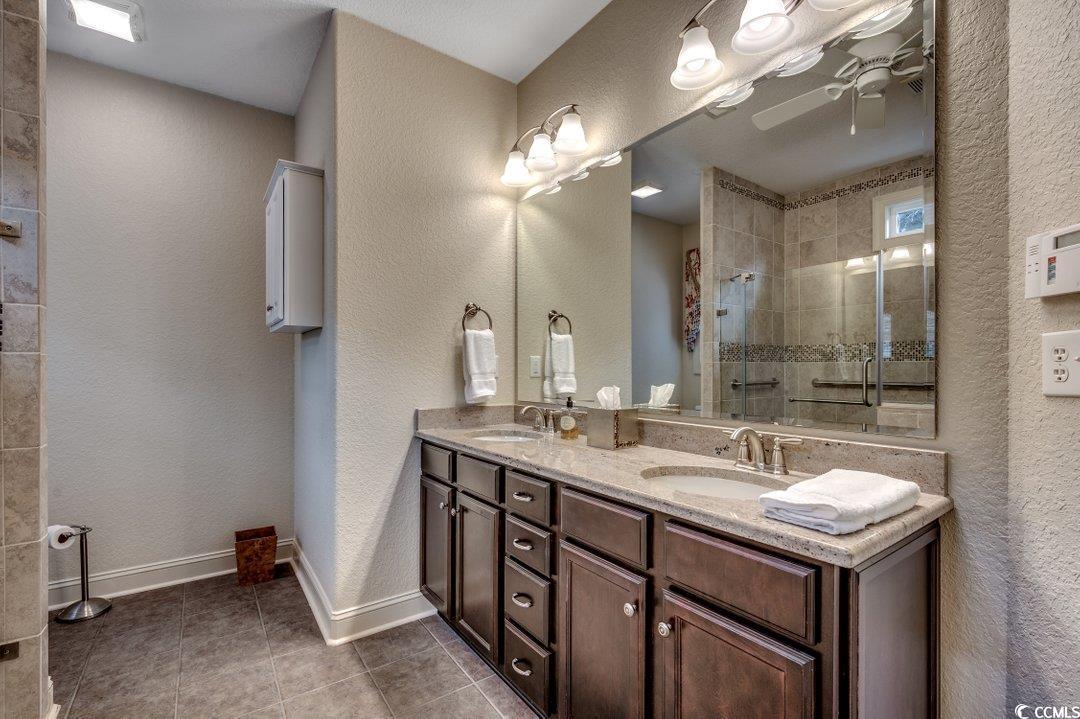 908 Corrado Street Myrtle Beach, SC 29572 - Photo 19 of 33 Bathroom with a textured wall, light tile patterned floors, double vanity, a stall shower, and ceiling fan