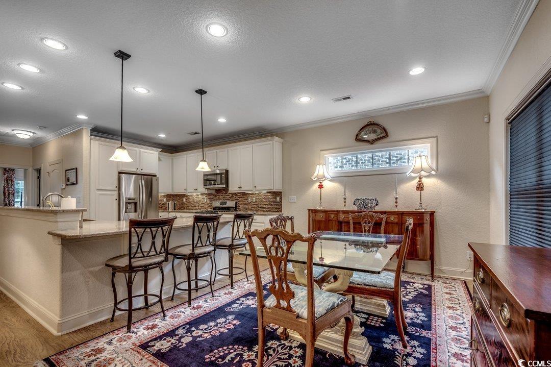 908 Corrado Street Myrtle Beach, SC 29572 - Photo 5 of 33 Dining room featuring crown molding, wood finished floors, a textured ceiling, recessed lighting, and a textured wall