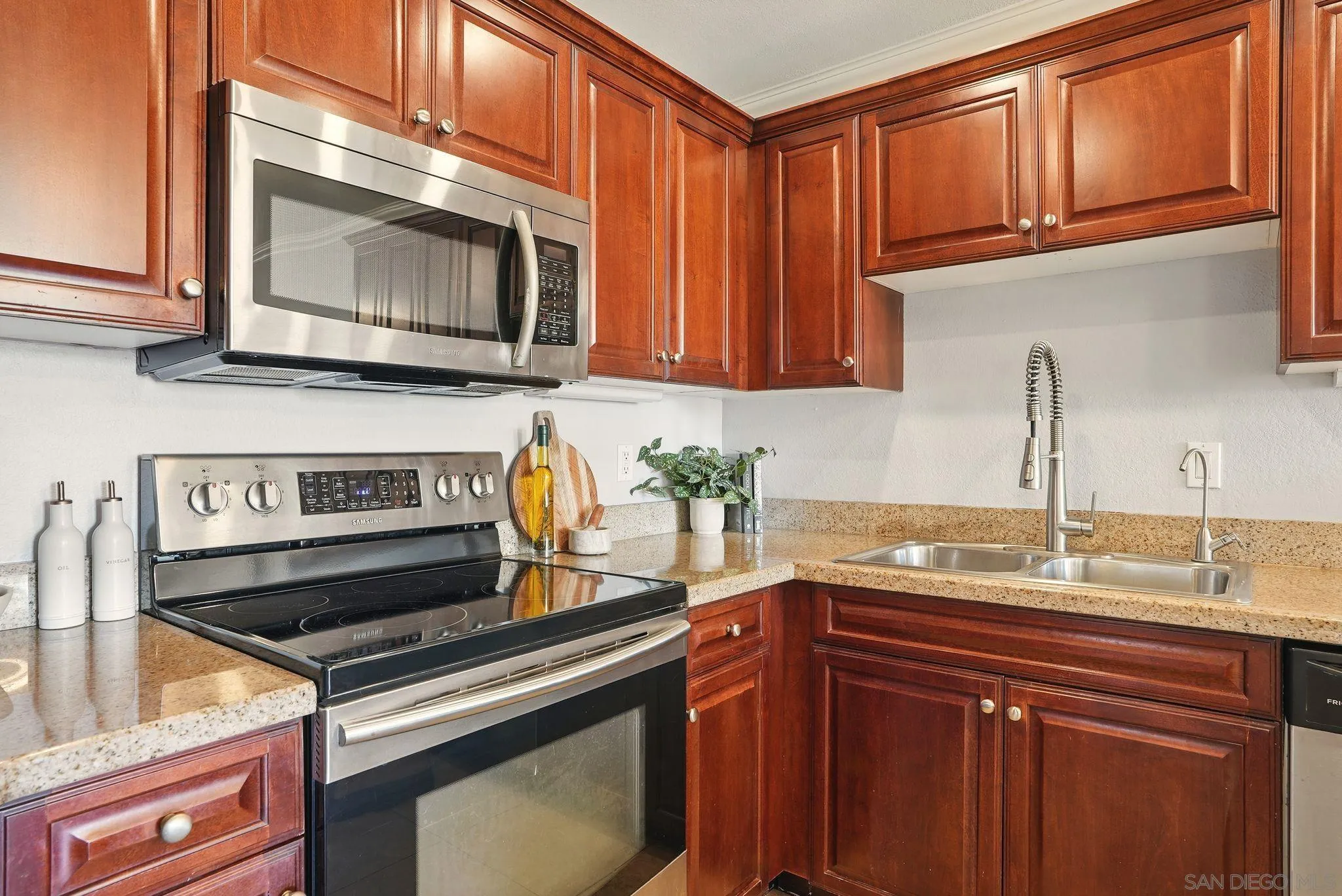 3545 Paseo De Francisco, Unit 231 Oceanside, CA 92056 - Photo 11 of 50 a kitchen with granite countertop a stove top oven microwave and cabinets