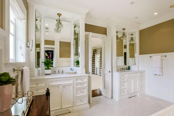 a spacious bathroom with a double vanity sink a mirror a and a shower