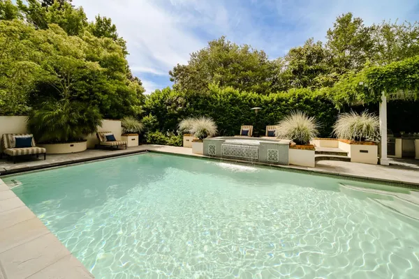a view of a house with swimming pool and sitting area