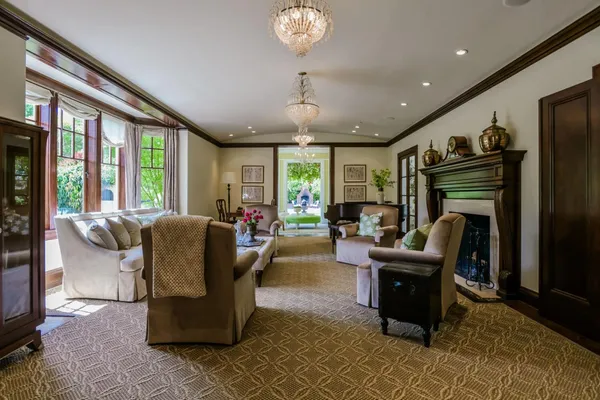 a living room with furniture a fireplace and a chandelier