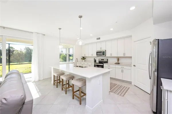 a kitchen with a sink stainless steel appliances and white cabinets
