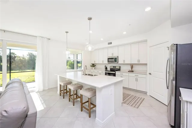 a kitchen with a sink stainless steel appliances and white cabinets