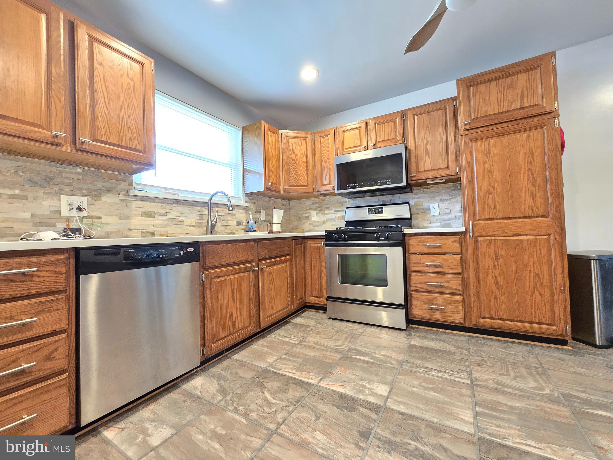 9003 Bruno Road Randallstown, MD 21133 - Photo 7 of 25 a kitchen with stainless steel appliances granite countertop a stove a sink dishwasher a refrigerator and a microwave oven