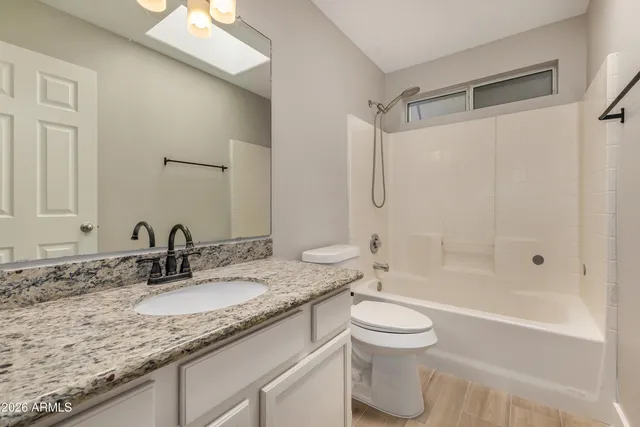a bathroom with a granite countertop sink toilet and shower