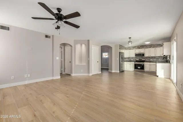 a view of a kitchen with a refrigerator a ceiling fan a kitchen microwave and a refrigerator