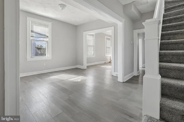 an empty room with wooden floor and windows
