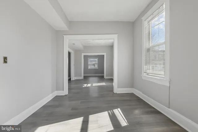 a view of a hallway with wooden floor and glass door