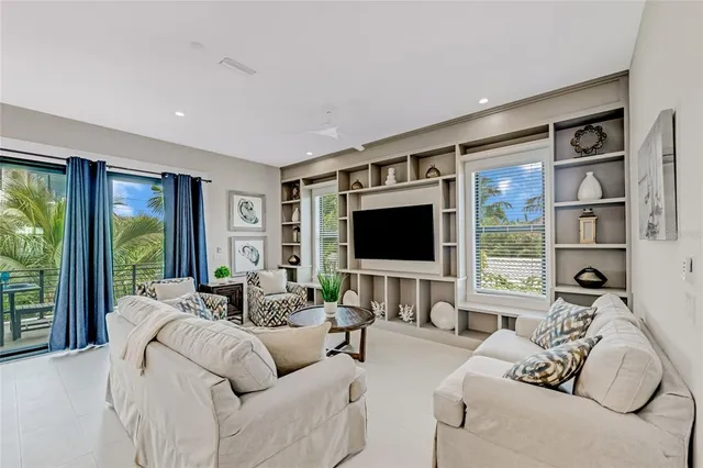 a living room with furniture a flat screen tv and a large window