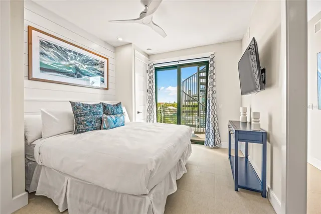 a bedroom with a large bed and a flat tv screen