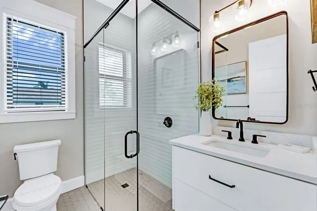 a bathroom with a sink a toilet and shower