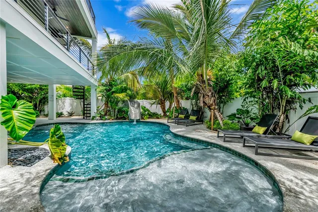 a living room with patio furniture and a potted plant