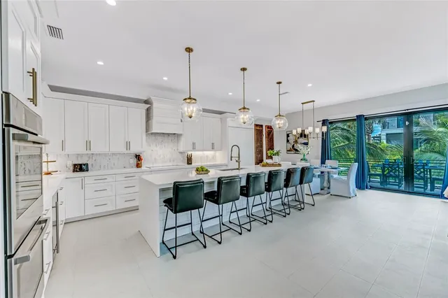 a large white kitchen with lots of counter space and windows