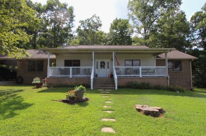 a view of a house with a yard and sitting area