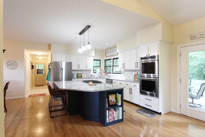 3157 Buckeye Road Erin, TN 37061 - Photo 7 of 41 a kitchen with stainless steel appliances kitchen island granite countertop a sink a microwave cabinets and wooden floor
