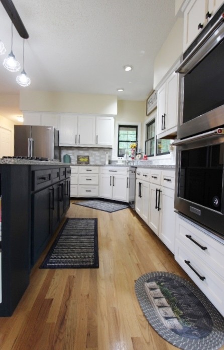 3157 Buckeye Road Erin, TN 37061 - Photo 9 of 41 a large kitchen with stainless steel appliances granite countertop a stove top oven a sink dishwasher and a microwave oven on the blue kitchen countertops with wooden floor