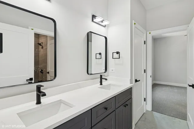 a bathroom with double vanity sinks and a mirror