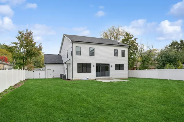 a front view of house with yard and trees in the background