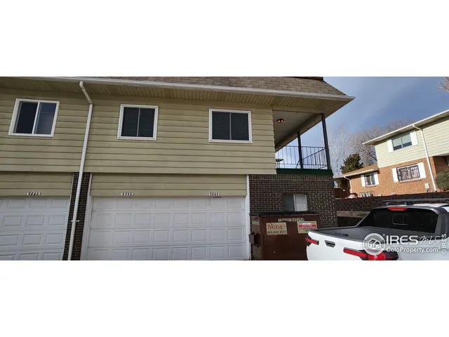 a picture of street with view of residential house and car parked
