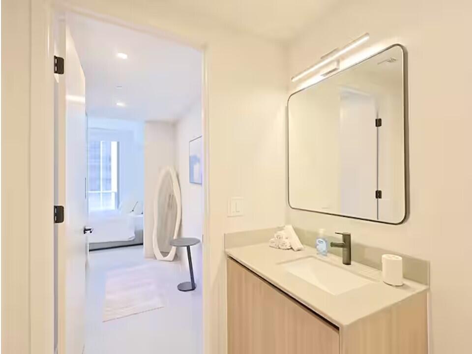 121 Northeast 5th Street Miami, FL 33132 - Photo 7 of 26 a bathroom with a sink vanity and a mirror