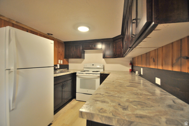 33 North 200 East Logan, UT 84321 - Photo 53 of 54 Kitchen featuring white appliances, dark brown cabinetry, and light wood-style floors