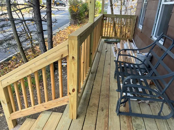 a view of balcony with wooden floor and fence