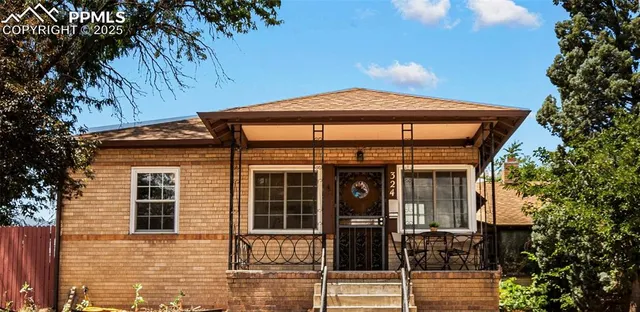 a front view of a house with glass windows and plants