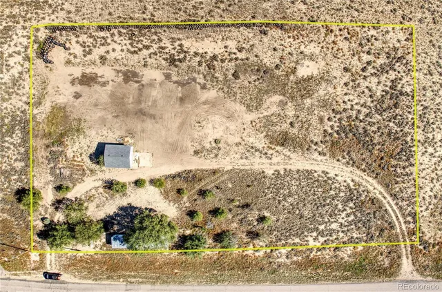 a view of a backyard with plants and white house