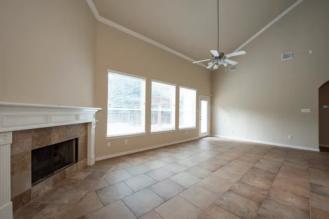 a view of an empty room with a fireplace and a window