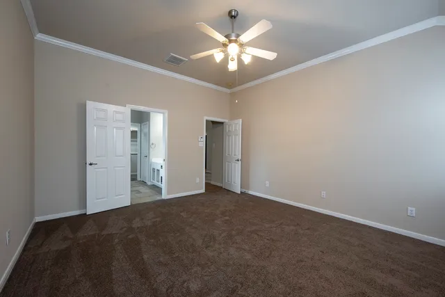 a view of an empty room with a chandelier fan