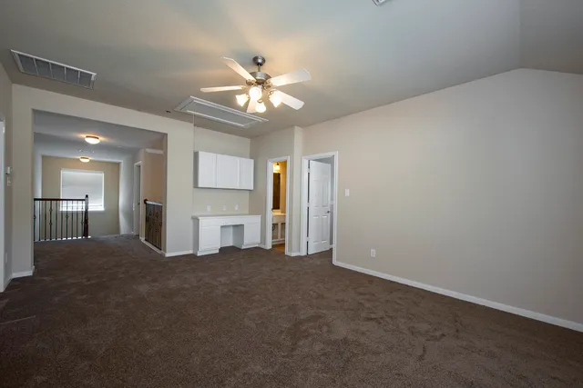 a view of a livingroom with a ceiling fan window and kitchen view