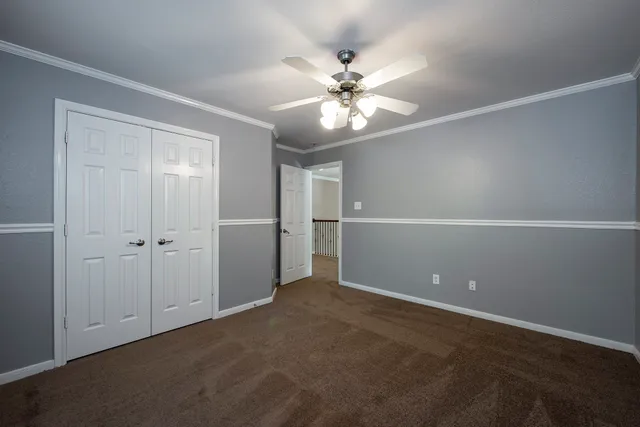 a view of an empty room with a ceiling fan