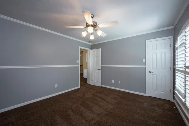 an empty room with closet and windows