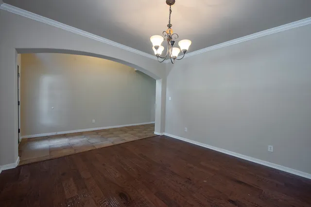 a view of a room with wooden floor and chandelier