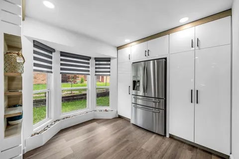 a kitchen with stainless steel appliances a refrigerator and wooden floor