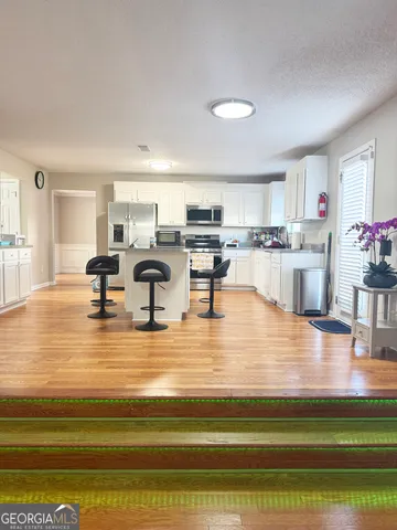 a dining room with kitchen island stove and wooden floor