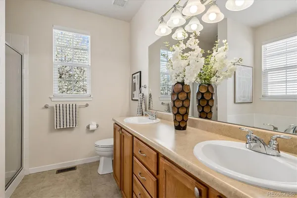 a bathroom with a double vanity sink toilet and a mirror