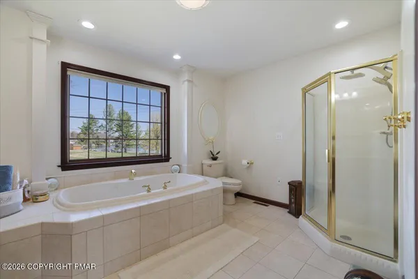 a spacious bedroom with a bed a window and a chandelier