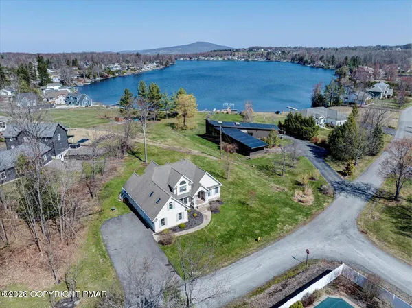 an aerial view of a house with a garden and lake view