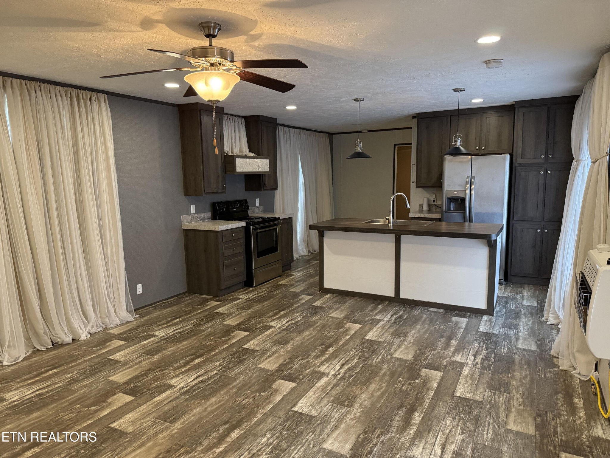 1366 Pearl Hinds Road Jamestown, TN 38556 - Photo 5 of 16 a kitchen with stainless steel appliances granite countertop a refrigerator a stove a sink dishwasher and a refrigerator with wooden floor