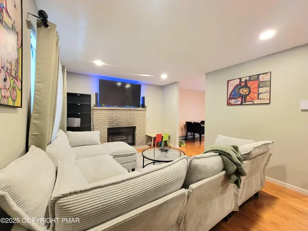 a living room with furniture a fireplace and a flat screen tv
